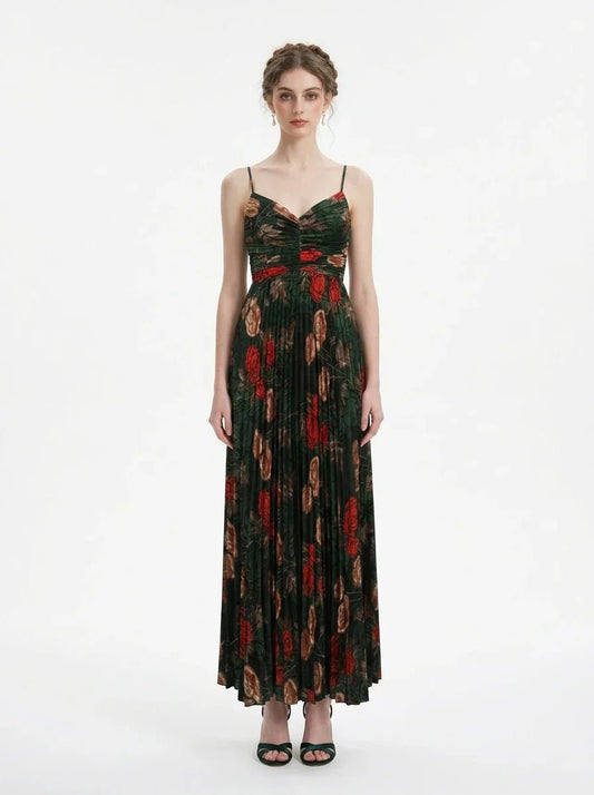 Woman wearing a dark green floral print maxi dress with spaghetti straps and a pleated skirt, front view.