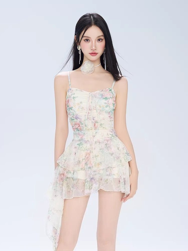 Woman wearing a floral print mini dress with spaghetti straps and a ruffled asymmetrical hem.