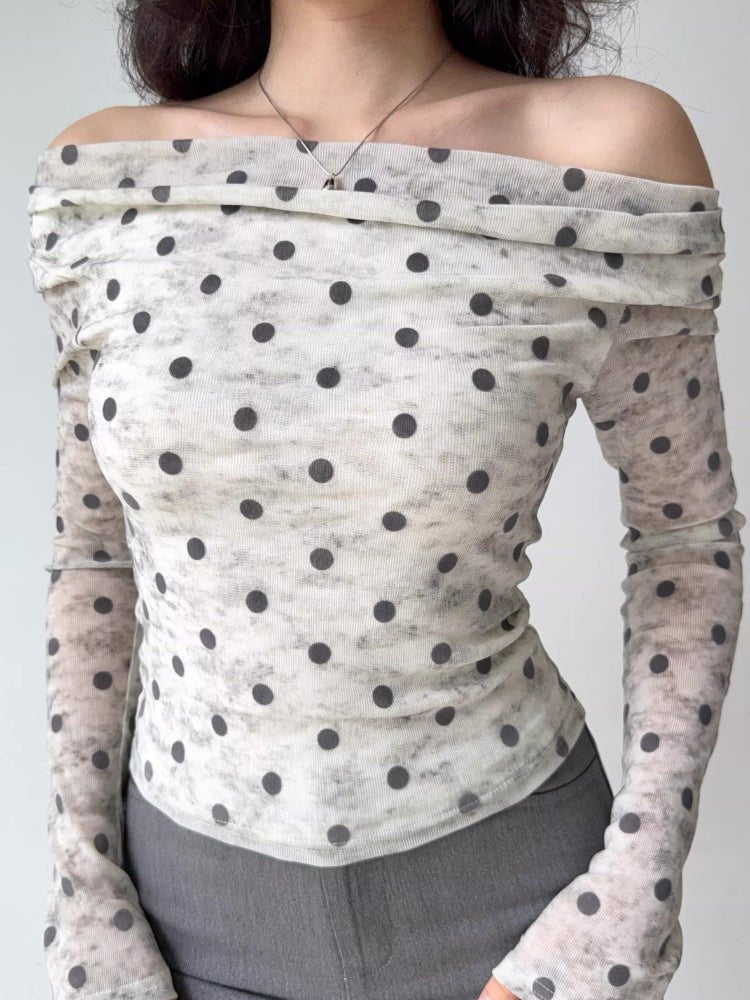 Front view of a woman in a white and grey polka dot off-the-shoulder mesh top
