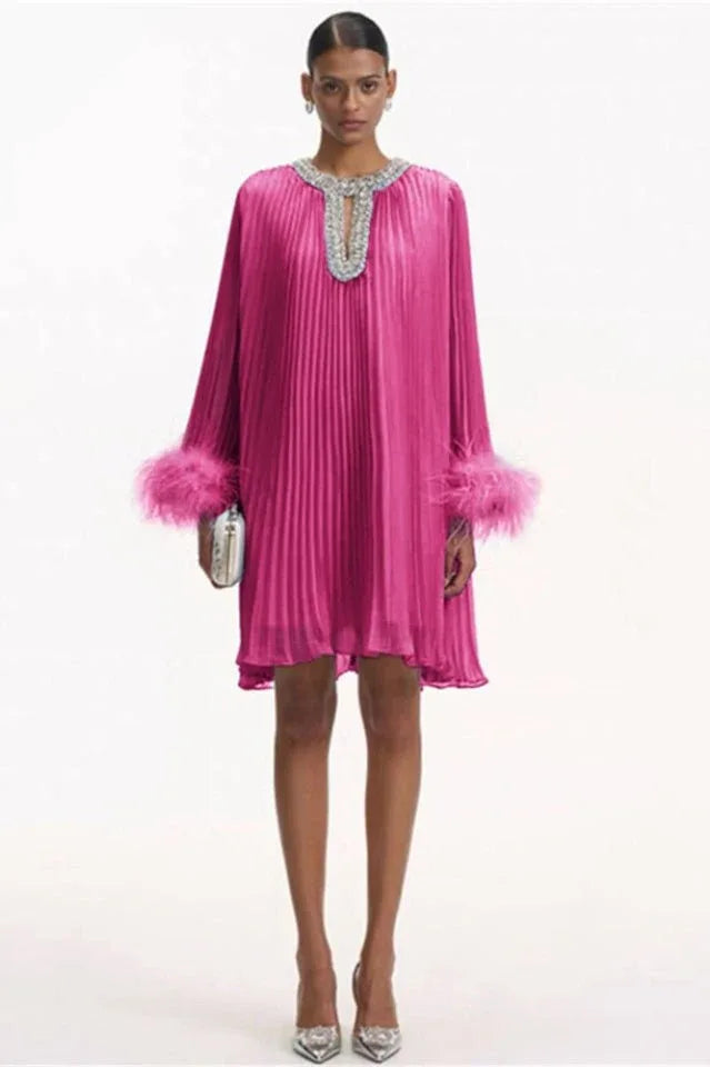 woman wearing a hot pink pleated mini dress with feather cuffs and an embellished neckline