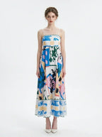 Full front view of a woman wearing a midi dress with an abstract geometric print and spaghetti straps.