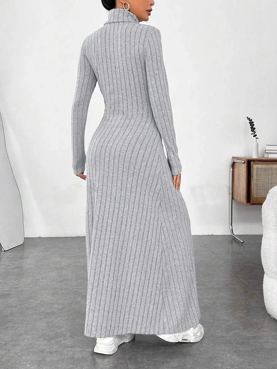 Back view of a woman wearing a grey ribbed knit maxi dress with a turtleneck and long sleeves.