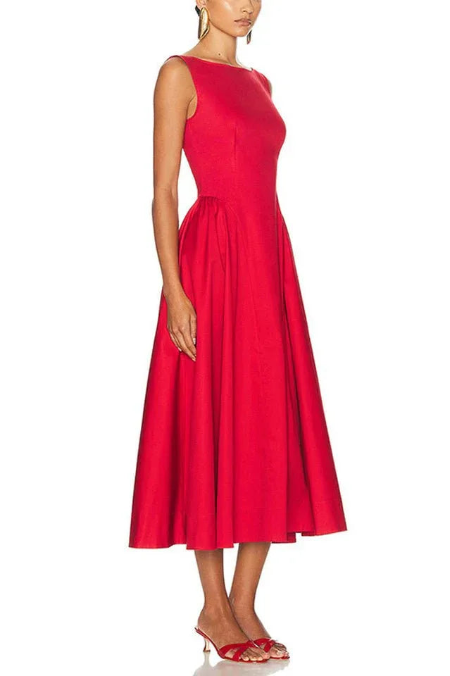 Side view of a model in a red sleeveless midi dress with a boat neck and full skirt.