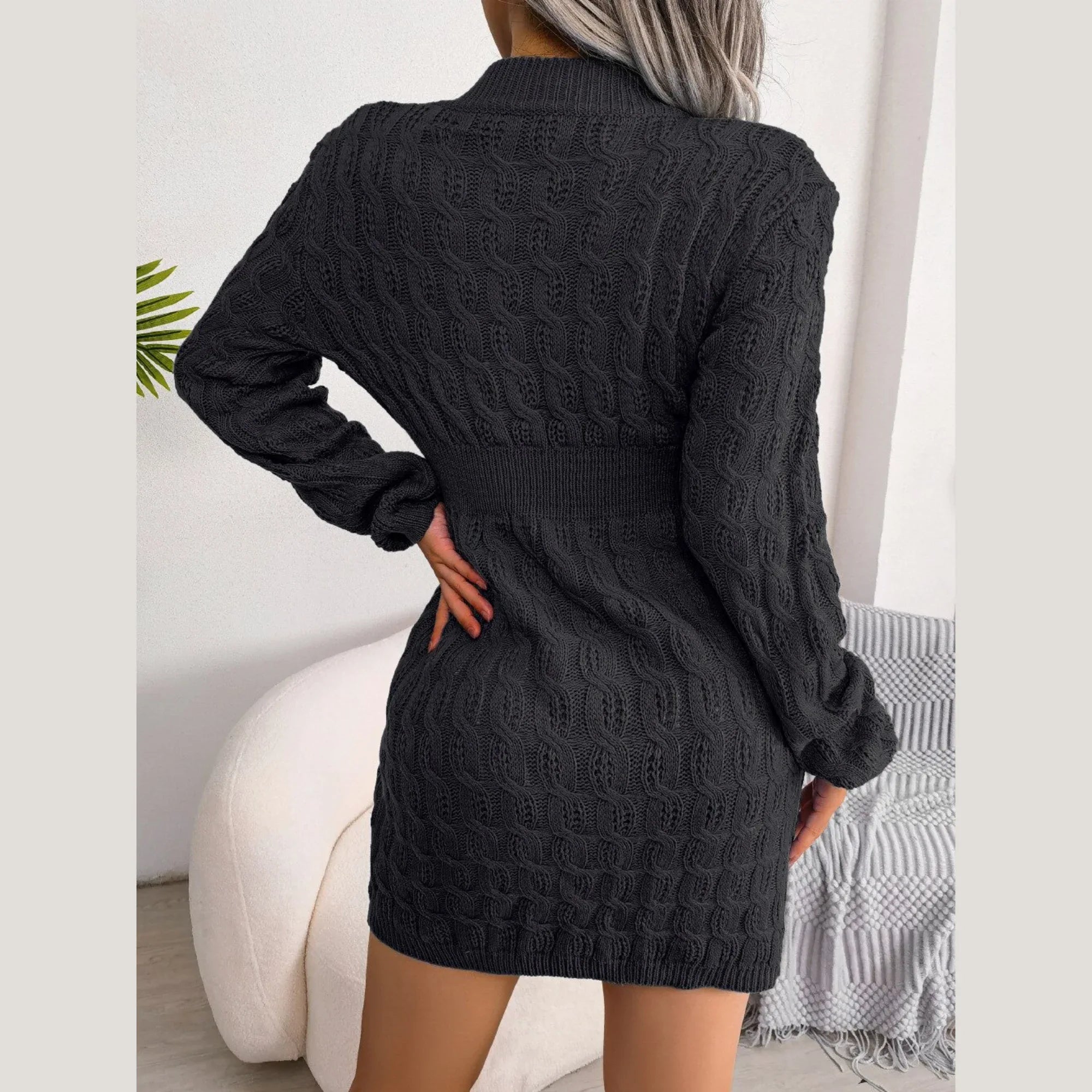 Back view of a woman wearing a black cable knit mini dress.