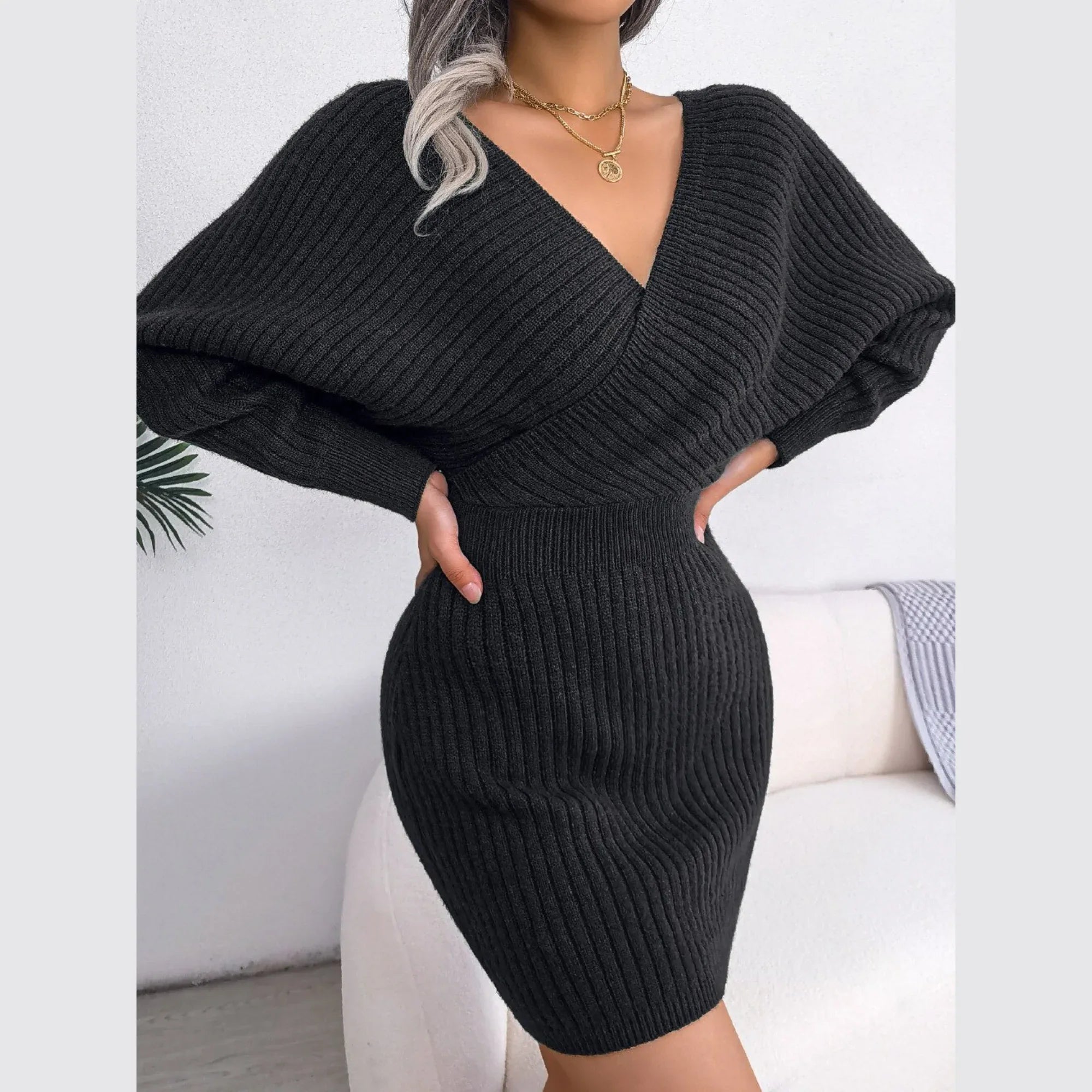 Model showcasing a fitted charcoal knit dress with a V-neckline.