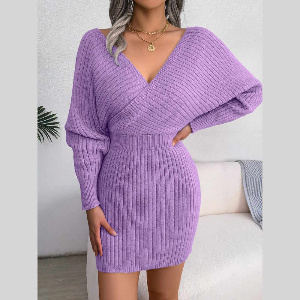 Woman posing in a purple knit mini dress with a V-neck and batwing sleeves.