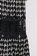 Close-up of the lace insert and geometric print on a black and white midi dress