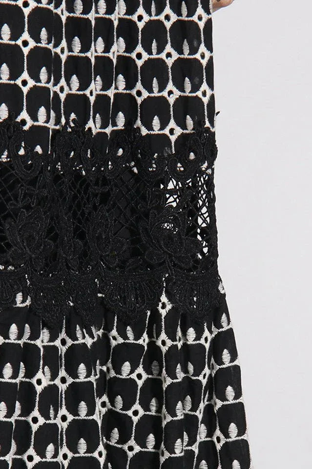 Close-up of the lace insert and geometric print on a black and white midi dress