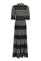 Full-length view of a black and white geometric print midi dress with lace details