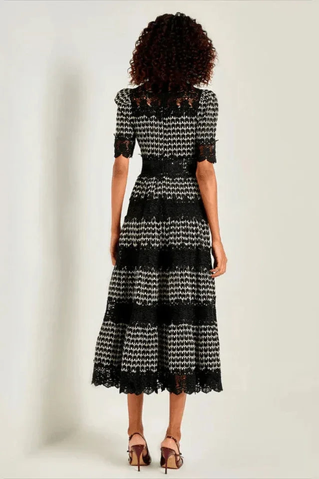 Back view of a woman in a black and white geometric print midi dress with lace details Secondary image