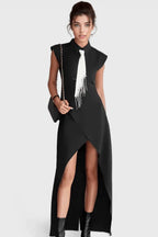 Woman wearing a black sleeveless maxi dress with a white tie detail and an asymmetrical hemline