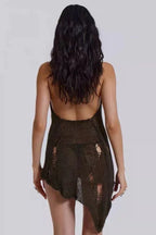 Back view of a model wearing a distressed knit halter mini dress, showcasing the open back and asymmetrical hem