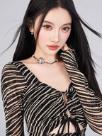 Close-up of the neckline and pattern of the black and gold striped sheer mesh mini dress.