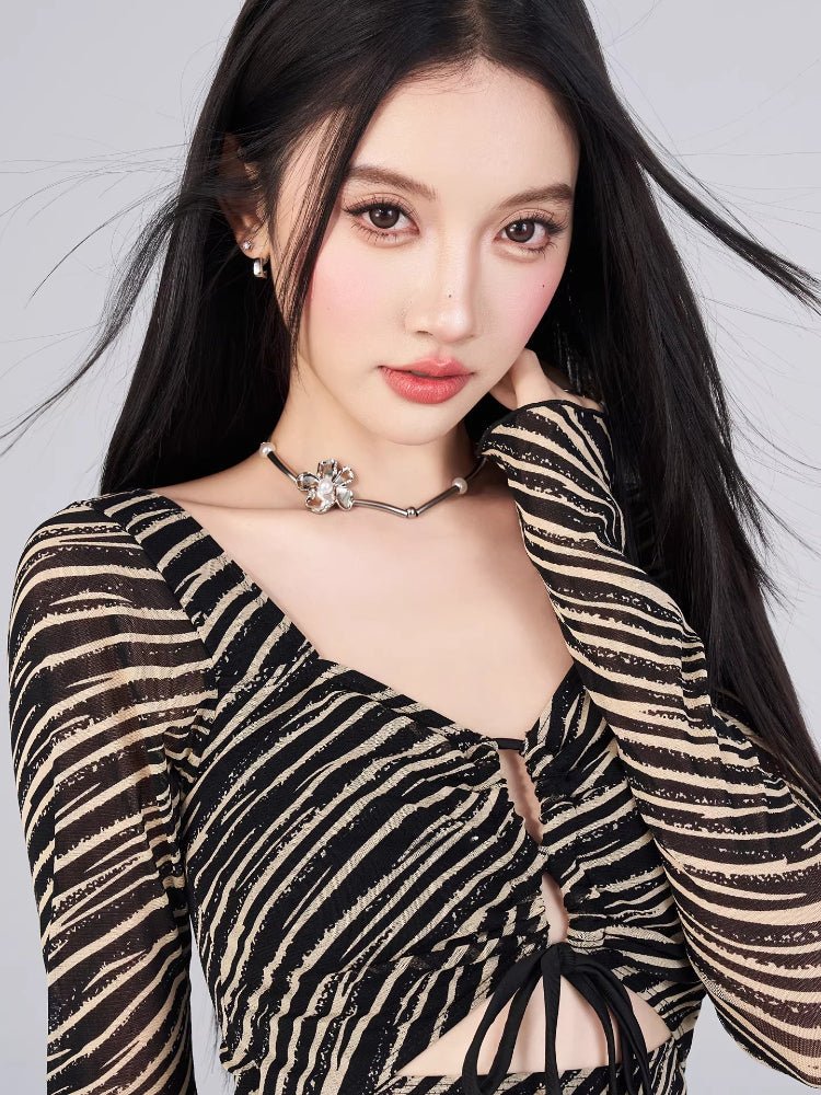 Close-up of the neckline and pattern of the black and gold striped sheer mesh mini dress.