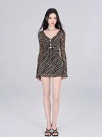 Full length shot of a model in a black and gold striped sheer mesh mini dress.