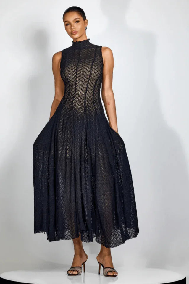 Full length view of a woman in a black mock neck midi dress with a flared skirt