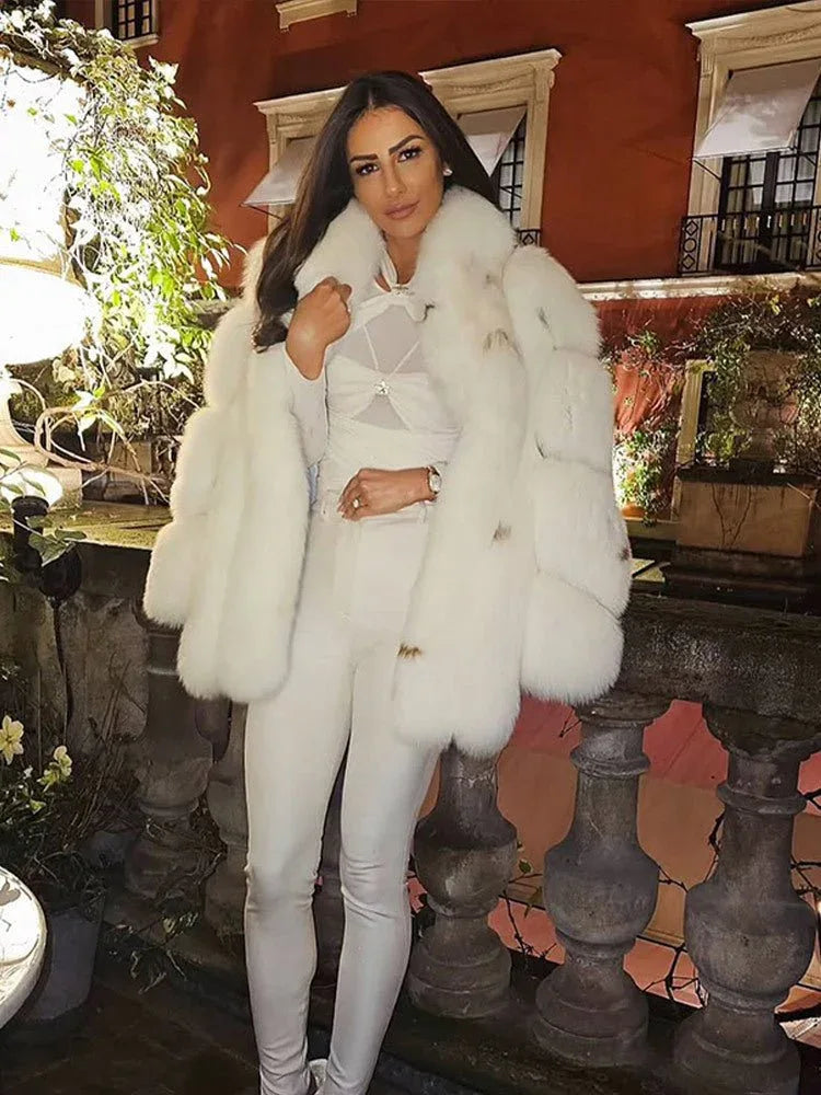 woman wearing a white faux fur coat with a white top and white pants Main image
