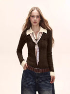 Woman wearing a dark brown fitted knit sweater with a cream collared shirt underneath and a patterned tie, paired with dark wash wide-leg jeans.