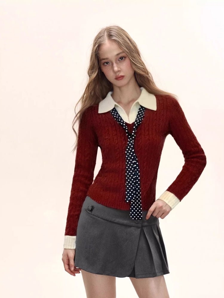 Woman wearing a red fitted knit sweater with a cream collared shirt underneath and a navy polka dot tie, paired with a grey pleated mini skirt.
