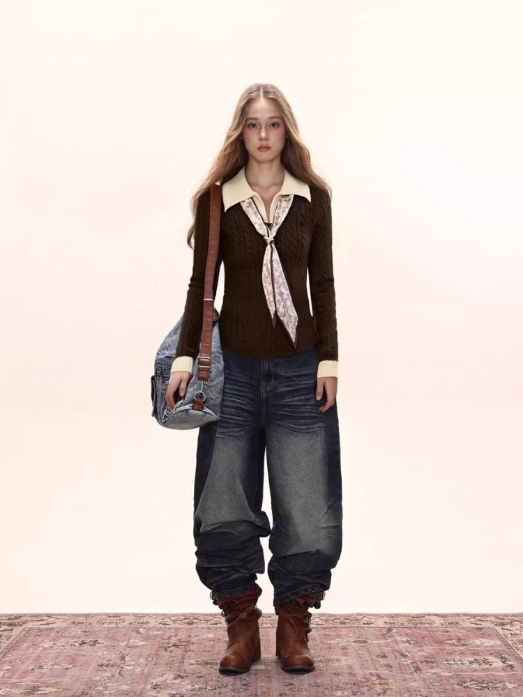Full body shot of a woman wearing a dark brown fitted knit sweater with a cream collared shirt underneath and a patterned tie, paired with dark wash wide-leg jeans and brown boots.