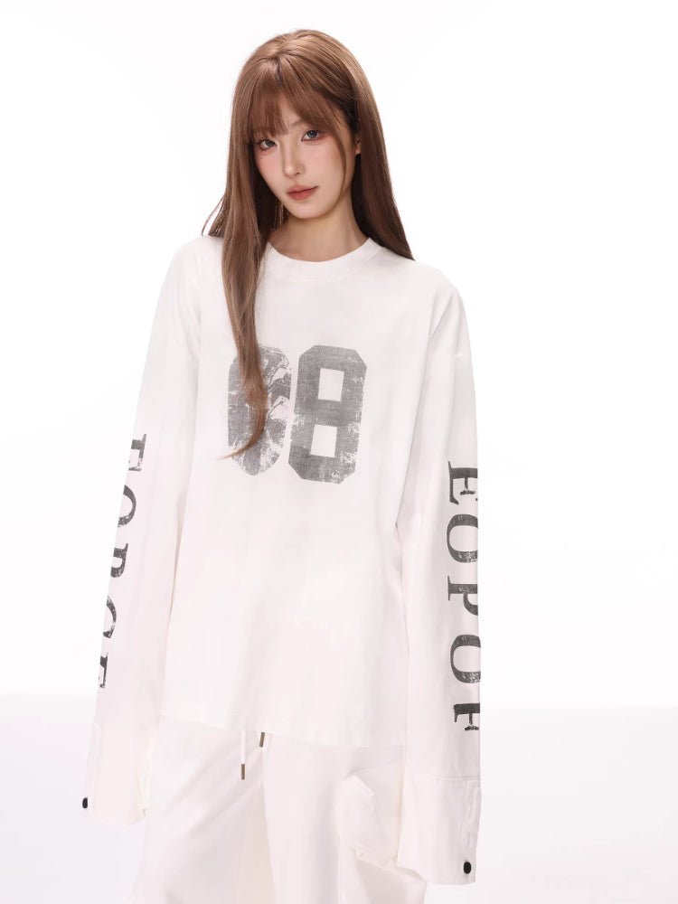 Close-up of a white long sleeve top with a "68" graphic and sleeve text.