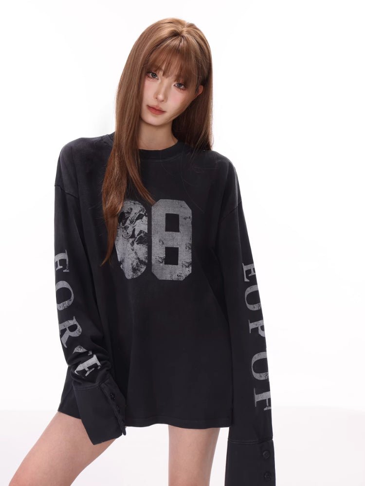 Close-up of a black long sleeve top with a "68" graphic and sleeve text.