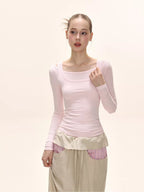 Model wearing a pink long-sleeved square neck top and a beige maxi skirt with pink striped accents.