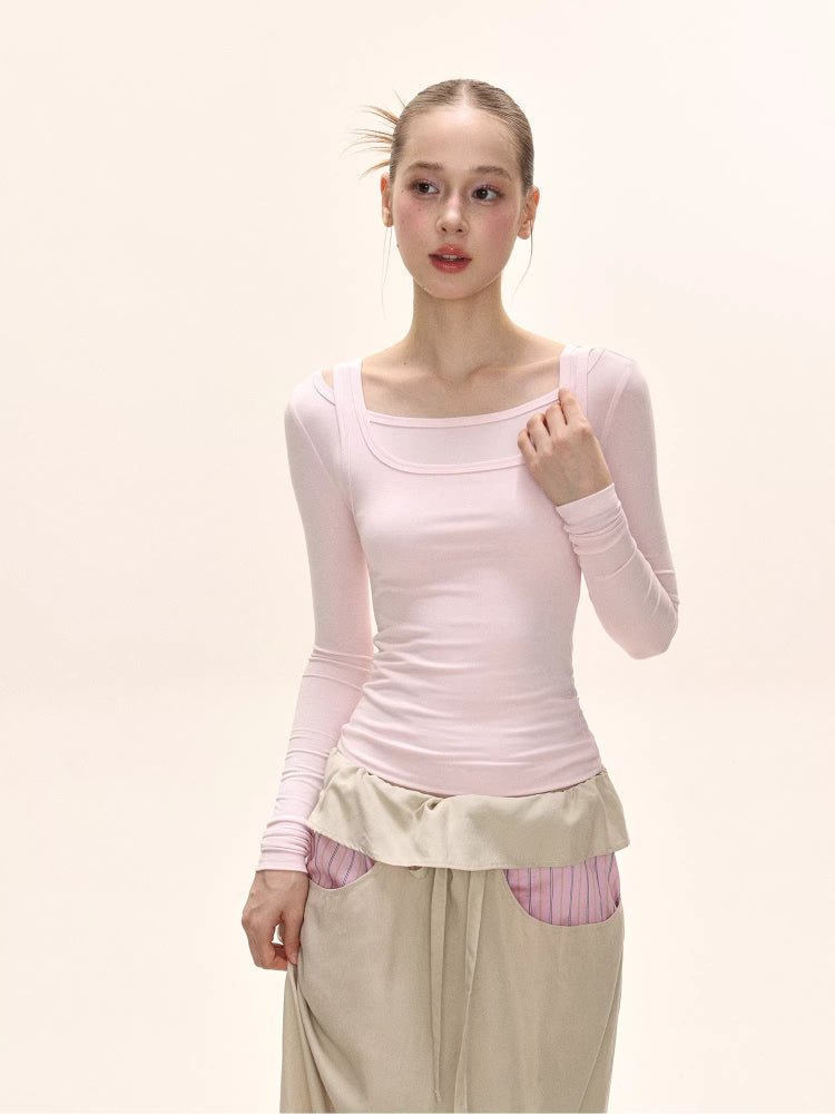 Model wearing a pink long-sleeved square neck top and a beige maxi skirt with pink striped accents.
