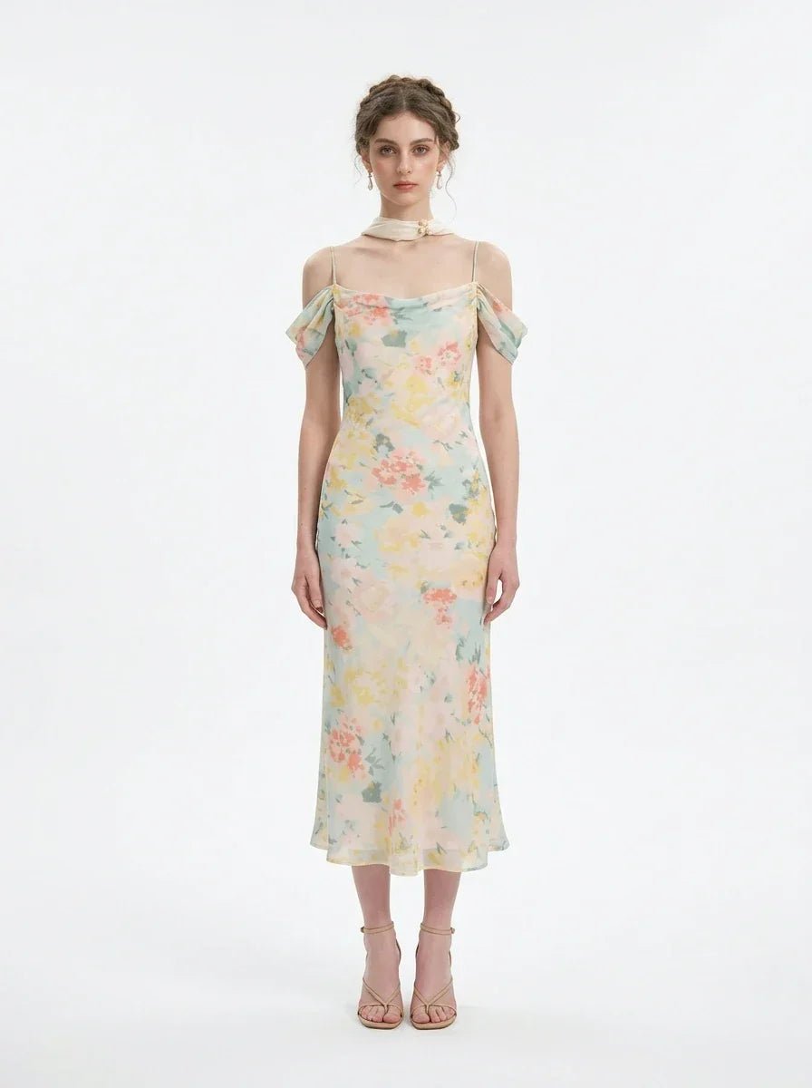 Woman wearing a floral print midi slip dress with off-the-shoulder sleeves and a cowl neckline, standing against a white background.