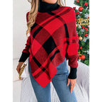 Woman holding a white clutch while wearing a red and black plaid turtleneck poncho with blue jeans.