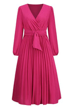 Front view of a long-sleeved pink wrap dress with a pleated skirt and a self-tie belt