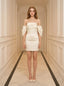 Woman in a white off-the-shoulder satin mini dress standing in a hallway.