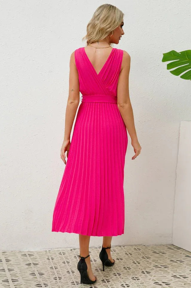 Back view of a woman in a bright pink sleeveless pleated midi dress