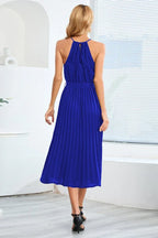 back view of a woman wearing a blue pleated halter dress
