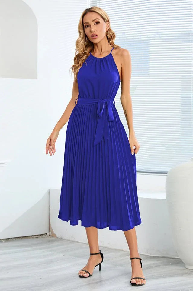 woman wearing a blue pleated halter dress with a tie waist Secondary image