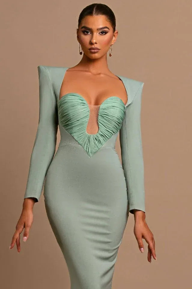 Model posing in a sage green long-sleeved mermaid dress with a sweetheart neckline.