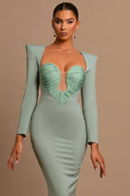 Model posing in a sage green long-sleeved mermaid dress with a sweetheart neckline.
