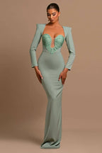 Full-length view of a woman in a sage green formal dress with a fitted silhouette and long sleeves.