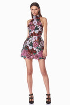 Front view of a model in a short, embellished halter dress with a floral pattern