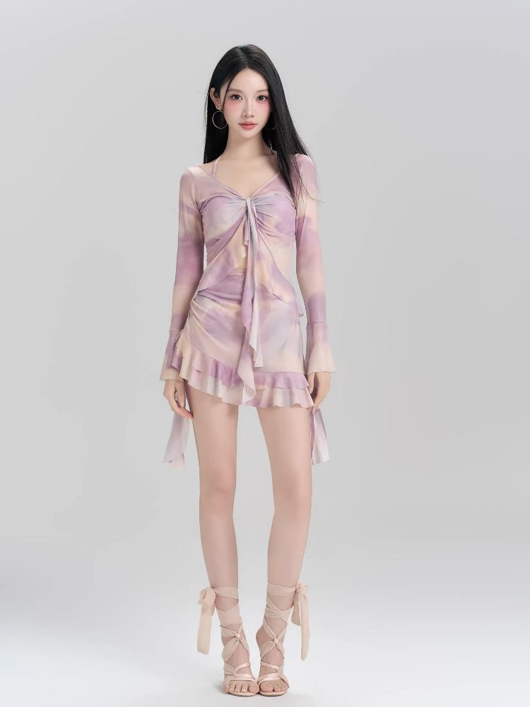 Full-length view of a woman in a purple and pink tie-dye mesh cover-up and matching bikini.