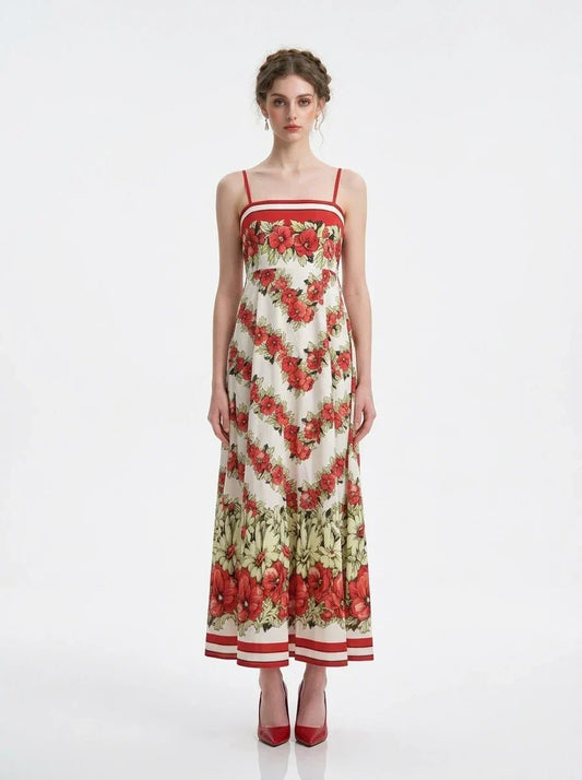 Woman wearing a floral print maxi dress with spaghetti straps, standing against a white background.