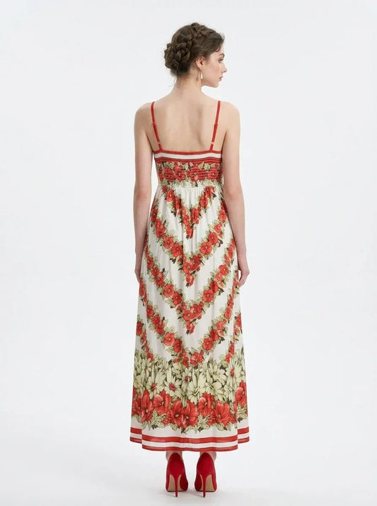 Back view of a woman in a floral print maxi dress with spaghetti straps, standing against a white background.