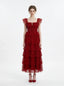 Woman in a red tiered tulle dress with ruffled sleeves and a square neckline, front view
