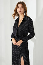 Woman wearing a black polka dot wrap dress with a tie waist