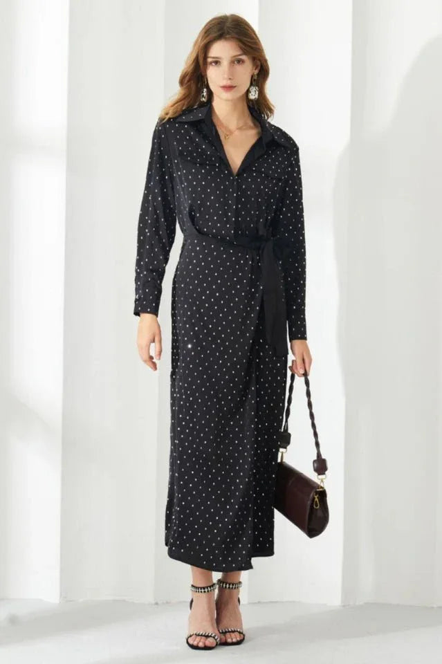 Woman wearing a black polka dot long sleeve belted wrap dress
