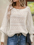 Front view of a white open-knit sweater with intricate diamond detailing.