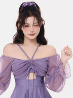 Close-up of the ruched bodice and sheer sleeves of the purple swimsuit.