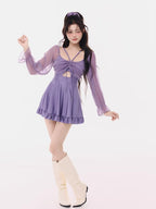 Full-body shot of the model in the purple swimsuit, posing with one leg extended.