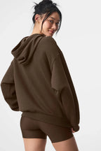 Back view of a woman wearing a brown cropped hoodie.